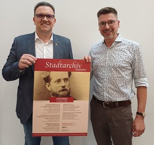 Das Bild zeigt Bürgermeister Michael Joithe und Stadtarchivar Rico Quaschny, die das Programm des Archivs für das zweite Halbjahr 2024 vorstellen