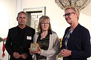 Vorsitzender des Beirats Michael Hufnagel, Preisträgerin Monika Wurm mit auf Holz aufgebrachter Plakette der goldenen Eule, stellvertretende Bürgermeisterin Eva Kirchhoff