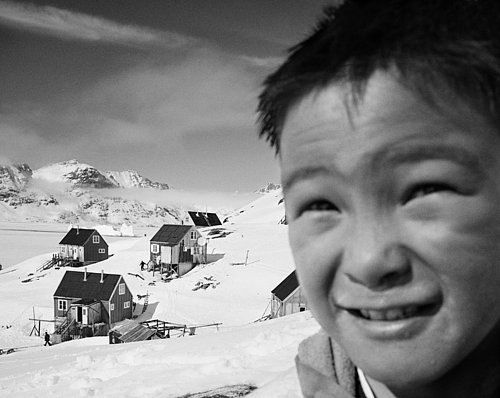 Inuit-Junge vor seinem Dorf auf Grönland