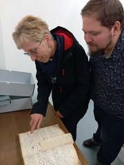 Foto: © Rico Quaschny / Stadtarchiv Iserlohn Die Schönebecker Archivare Britta Meldau und Mathias Hille betrachten im Stadtarchiv Iserlohn den Eintrag über die Aufnahme von Tolbergs Vater im Iserlohner Bürgerbuch.