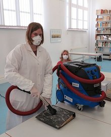 Restauratorin Friederike Nithack vom LWL-Archivamt (l.) und ihre Kollegin Sabrina Heumüller erläuterten dem Team des Stadtarchivs den Gebrauch des Sicherheitssaugers. (Foto: Rico Quaschny) 