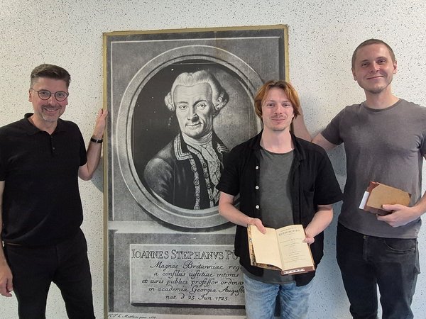 Stadtarchivar Rico Quaschny, Patric Rode und Eric Witt, die Vortrag und Lesung vorbereitet haben, vor einem Porträt von Johann Stephan Pütter.