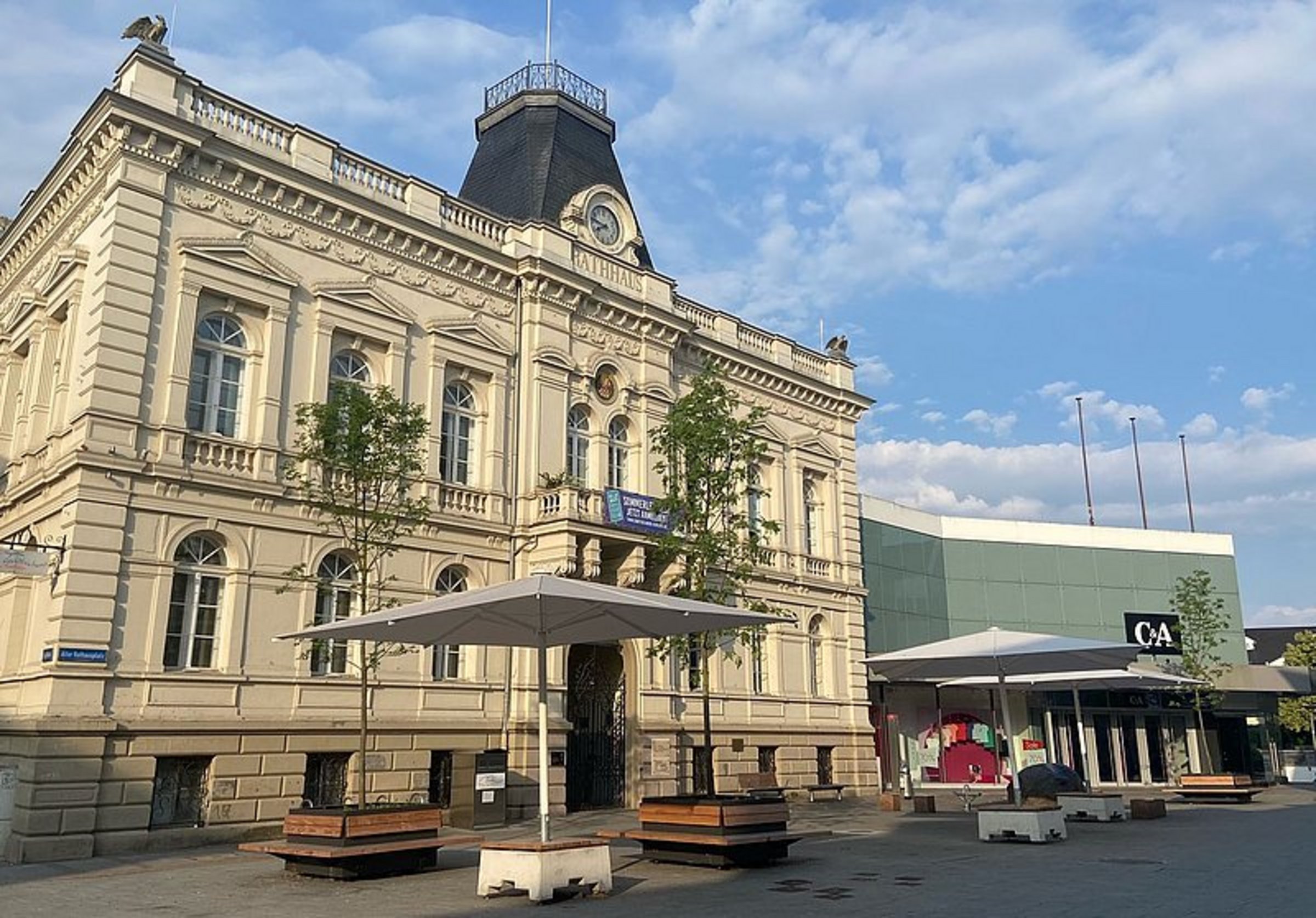 Das Bild zeigt Pflanzkübel und Sonnenschirme auf dem Alten Rathausplatz.