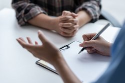 Das Bild zeigt zwei Menschen in einer Beratungssituation.