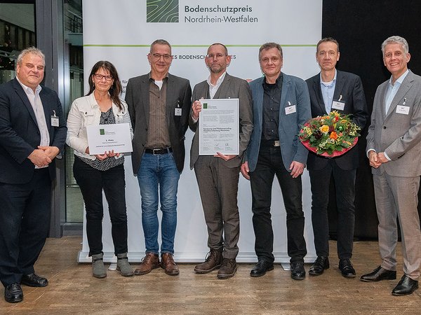 Für die Stadt Iserlohn nahmen (von der Mitte nach rechts) Thorsten Grote (Ressortleiter Ressort VI – Planen, Bauen, Umwelt- und Klimaschutz, Stadtbaurat und Technischer Beigeordneter), Hans-Jörg Saure (Abteilungsleiter Umwelt- und Klimaschutz), sowie Jörg Schürmann (Technischer Umweltschutz), die Auszeichnung entgegen.