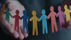 Das Bild zeigt Hände, die bunte Papier-Männchen halten.