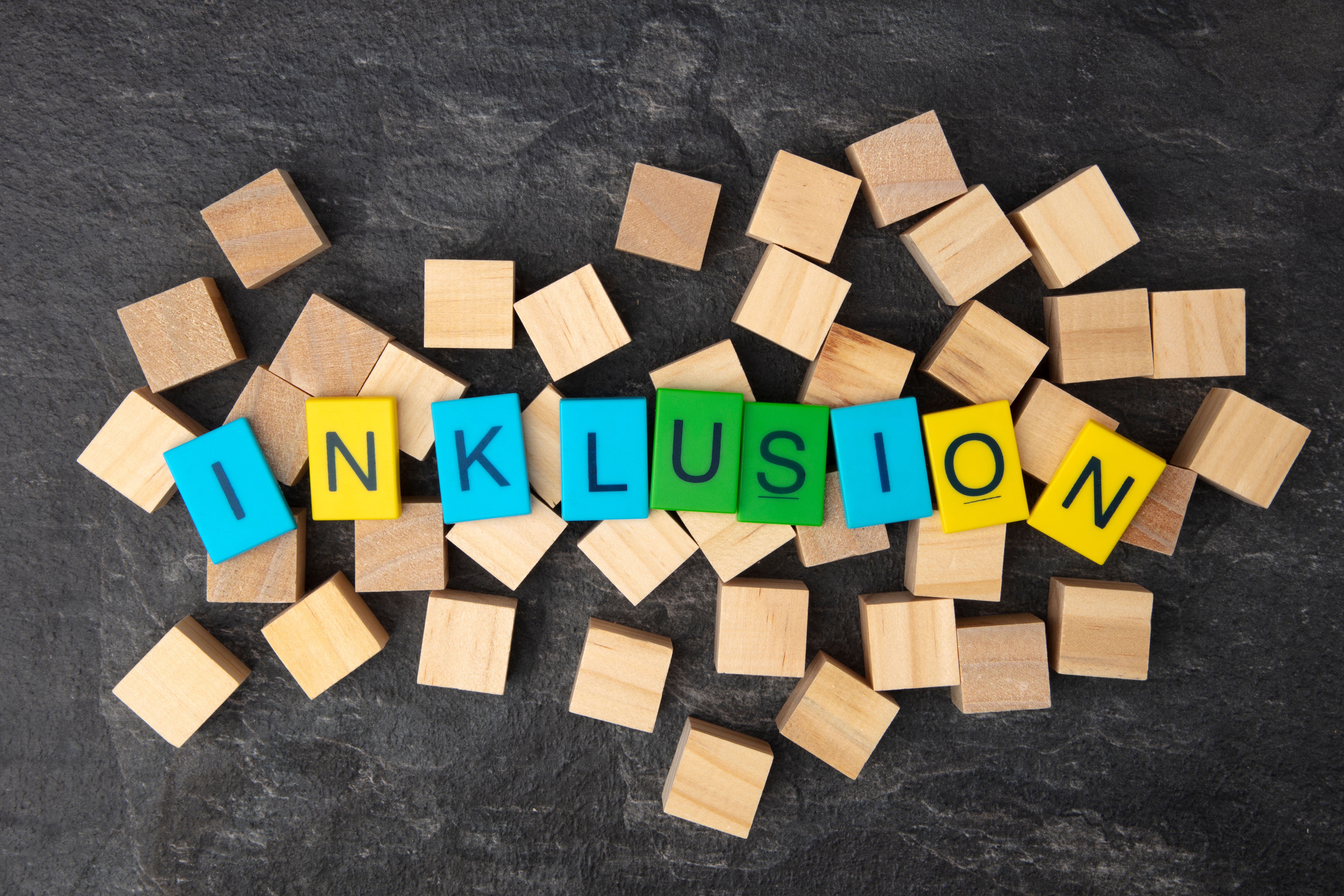 Das Bild zeigt Holzwürfel mit Buchstaben, die das Wort "Inklusion" bilden.