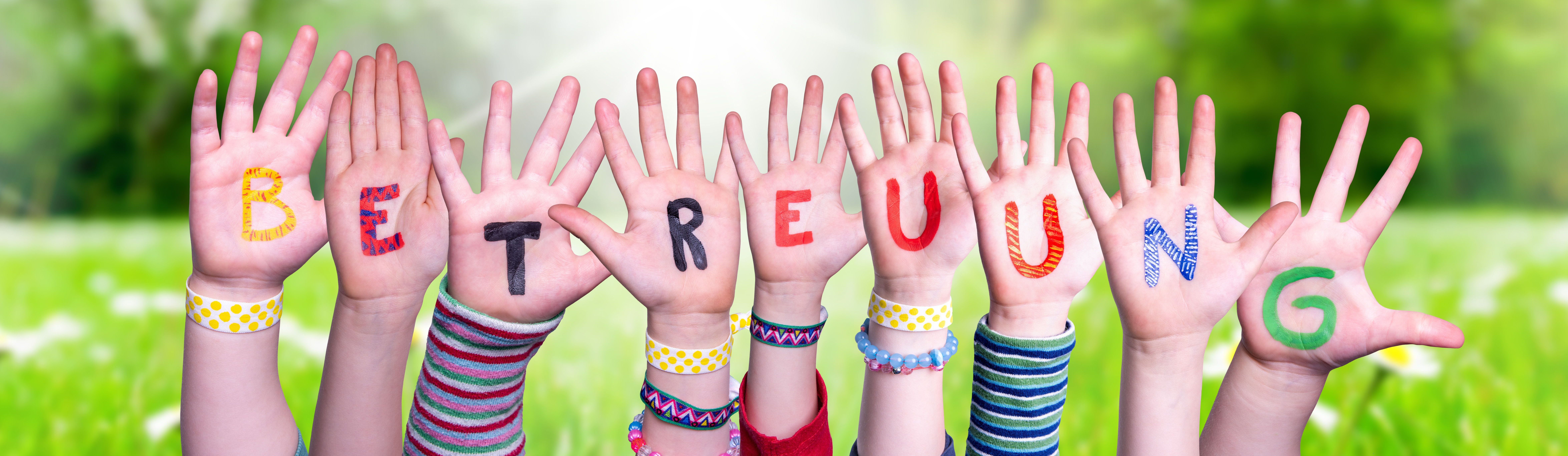 Das Bild zeigt Kinderhände mit Buchstaben, die das Wort "Betreuung" ergeben