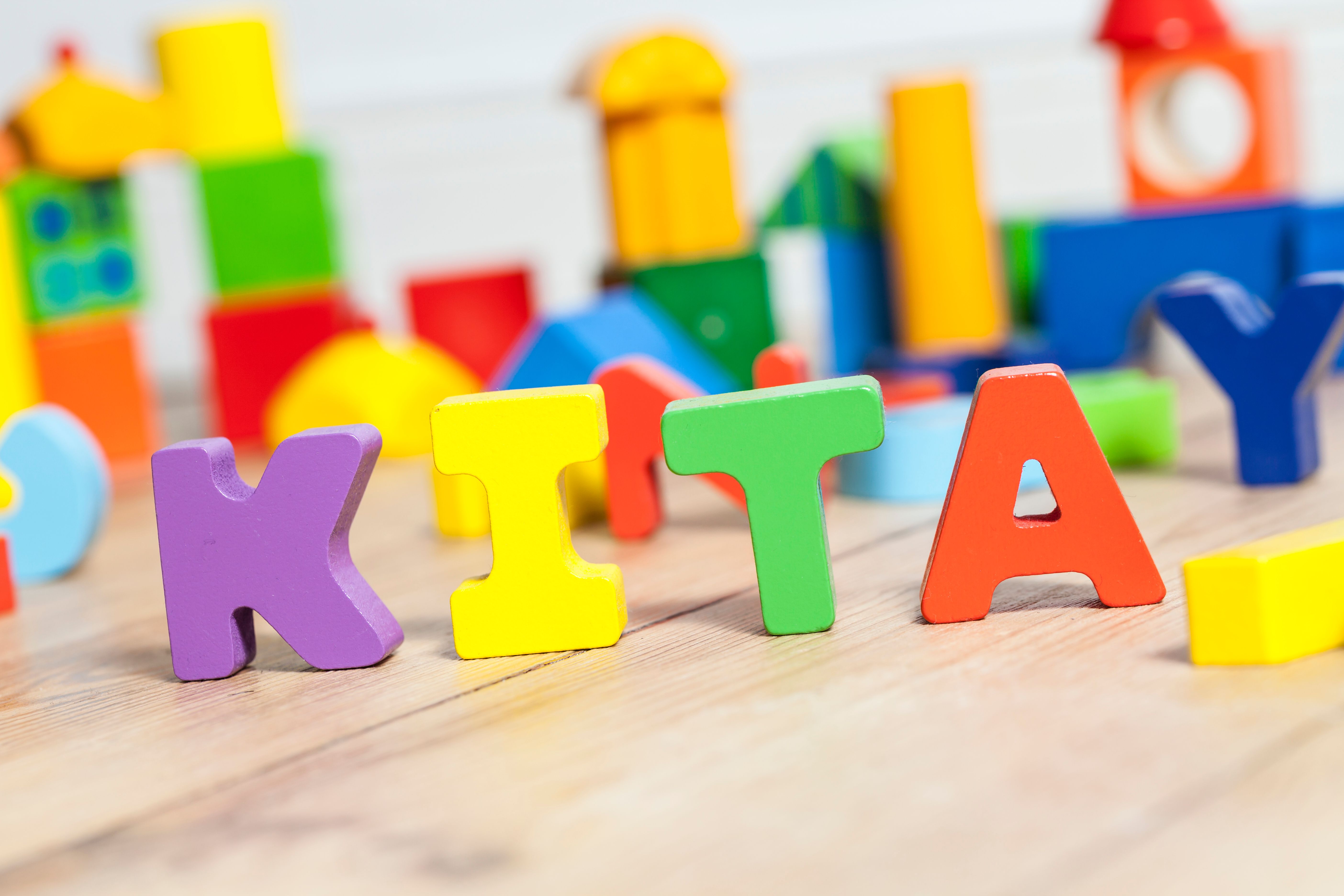 Das Bild zeigt das Wort "Kita" aus Holzbuchstaben.