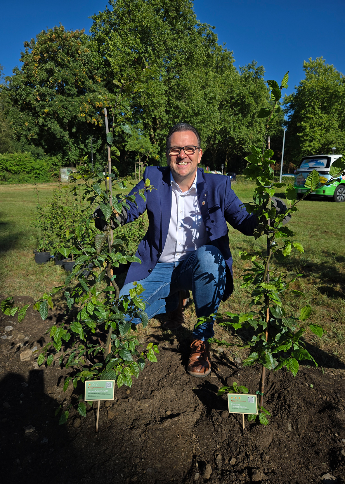 Bürgermeister Michael Joithe pflanzt Bäume.
