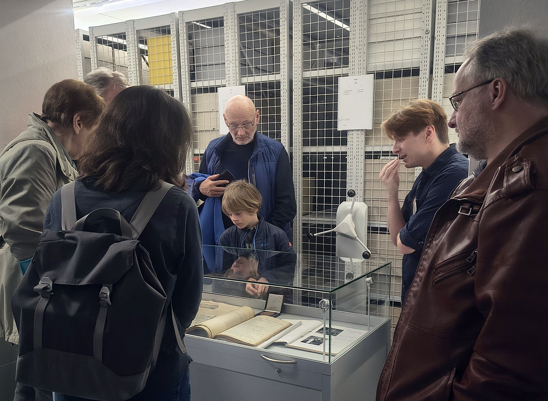 Patric Rode, Mitarbeiter im Stadtarchiv, zeigt einer Besuchergruppe Archivgut zur Geschichte des Stadtarchivs.