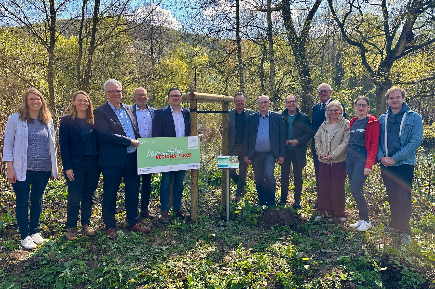 Bürgermeister Michael Joithe (5. v. l.) betonierte gemeinsam mit den Bürgermeistern der Partnerkommunen sowie mit Unterstützung durch die Südwestfalen Agentur GmbH und den Regionalmanagerinnen und -managern der drei LEADER-Regionen, das letzte Hinweisschild zur 'Essbaren Lenneschiene'.