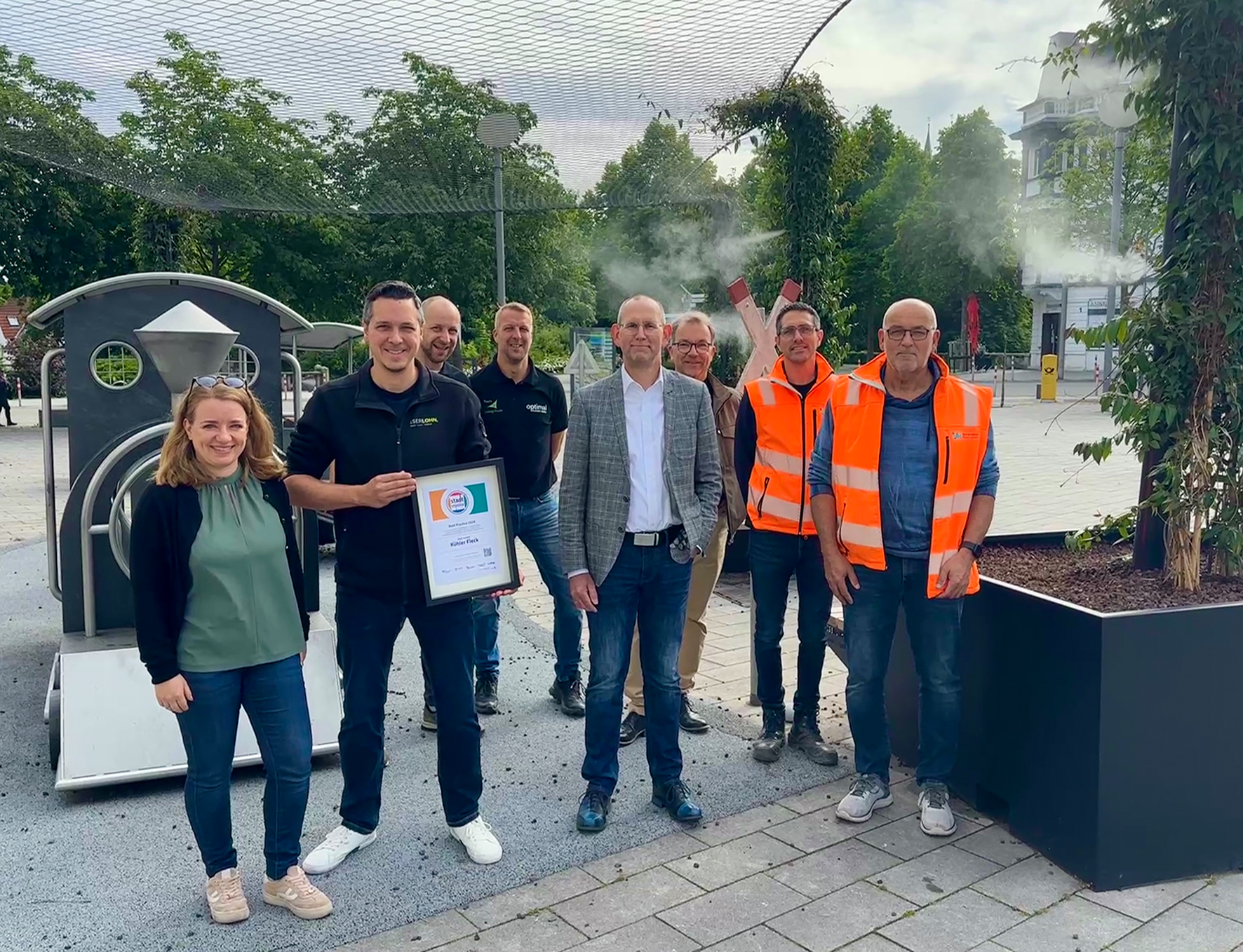 Ideengeber und Abteilungsleiter für Grünflächen und Friedhöfe Martin Irmer (3.v.r.) und Stadtbaurat Thorsten Grote (4.v.r.) freuen sich gemeinsam mit Victoria Verrieth (1.v.l.) und Sebastian Matz (2.v.l.) aus der Abteilung Stadtentwicklung sowie mit Vertretern des Stadtbetriebs Iserlohn/Hemer (SIH) und der ausführenden Firma "Optimal Planen GmbH" über die Auszeichnung.