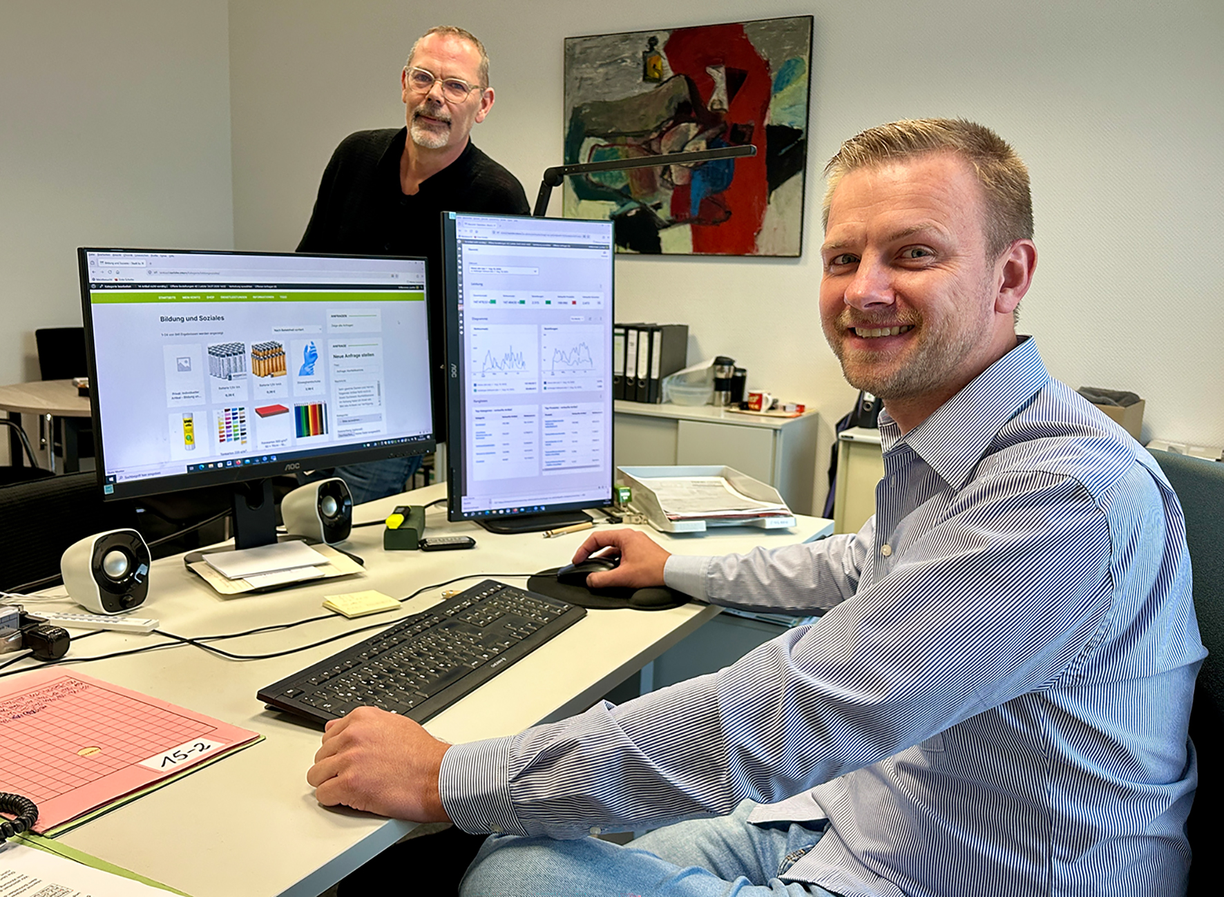 Martin Kozielski (rechts) präsentiert mit Thomas Pütter (links) die Eigenentwicklung einer softwaregestützten Einkaufs- und Serviceplattform. 