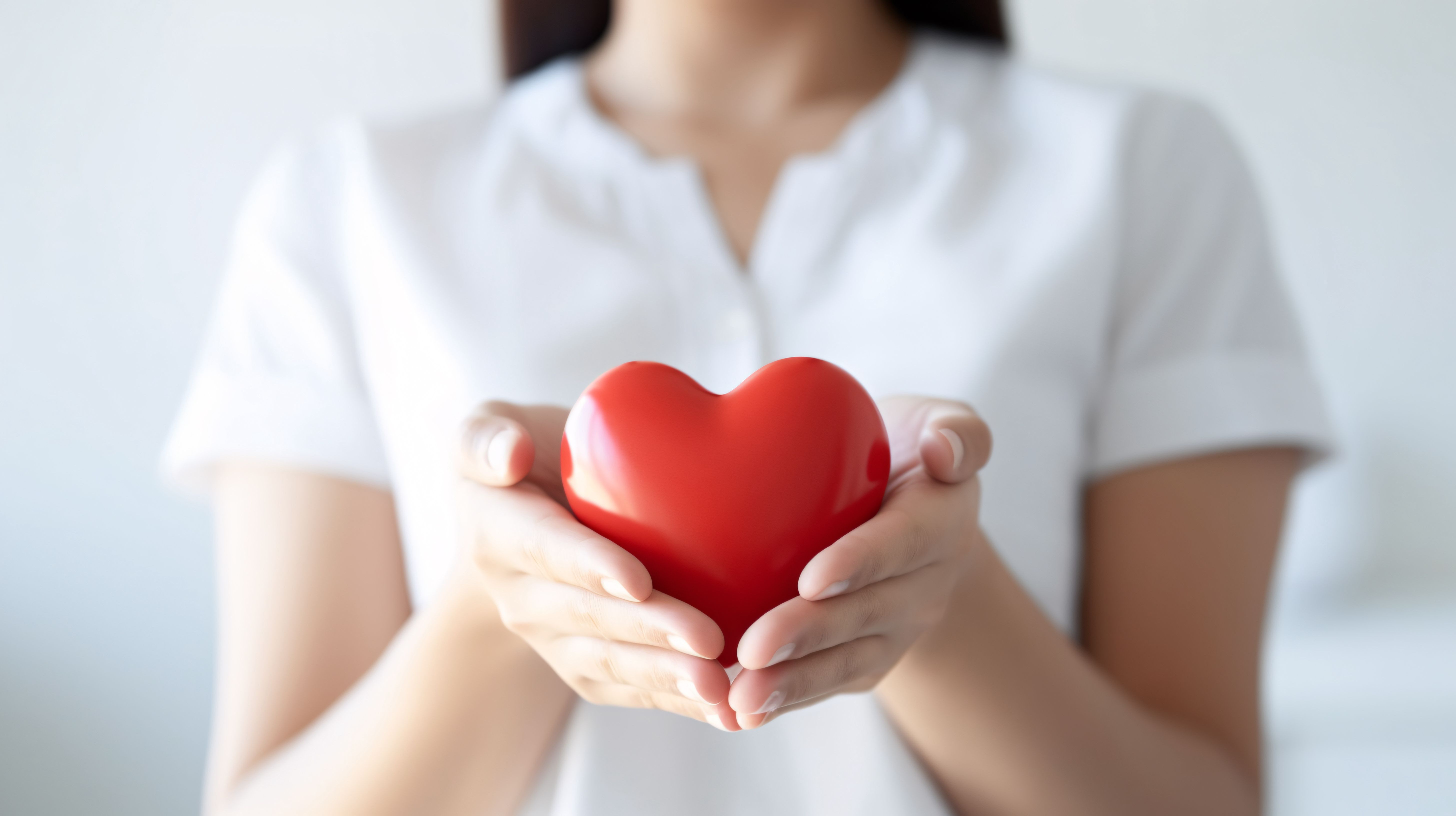 Das Bild zeigt eine Frau, die ein Herz in den Händen hält.